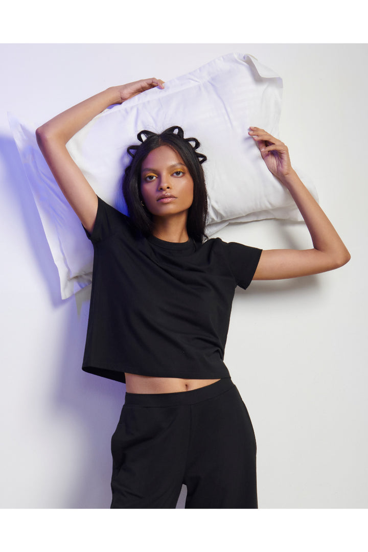 Black Supima® T-shirt on model with pillow, stylish casual look.