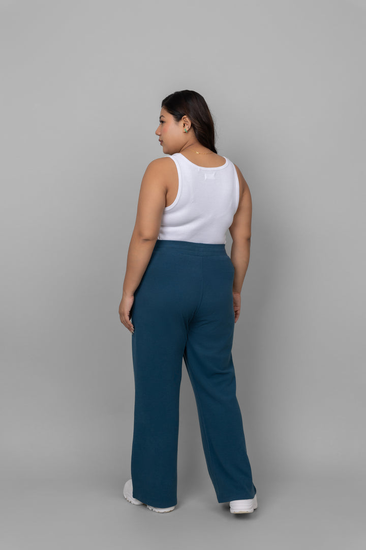 White rib tank top worn with blue pants from the back.