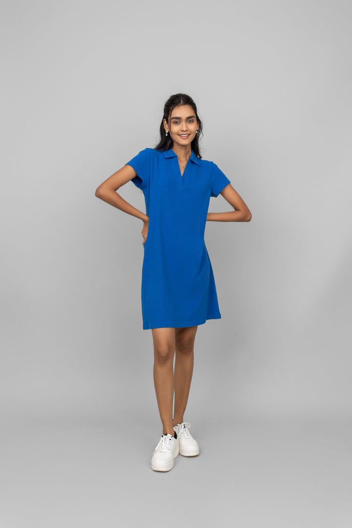 Model wearing a blue mini waffle short polo dress with sneakers.