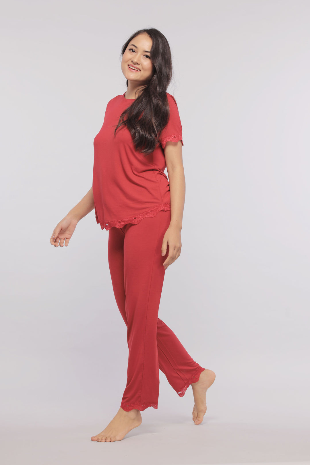Romantic red lace pajama set on a smiling woman.