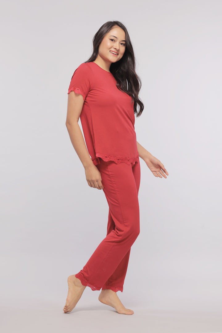 Romantic red lace pajama set showcased on a smiling model.