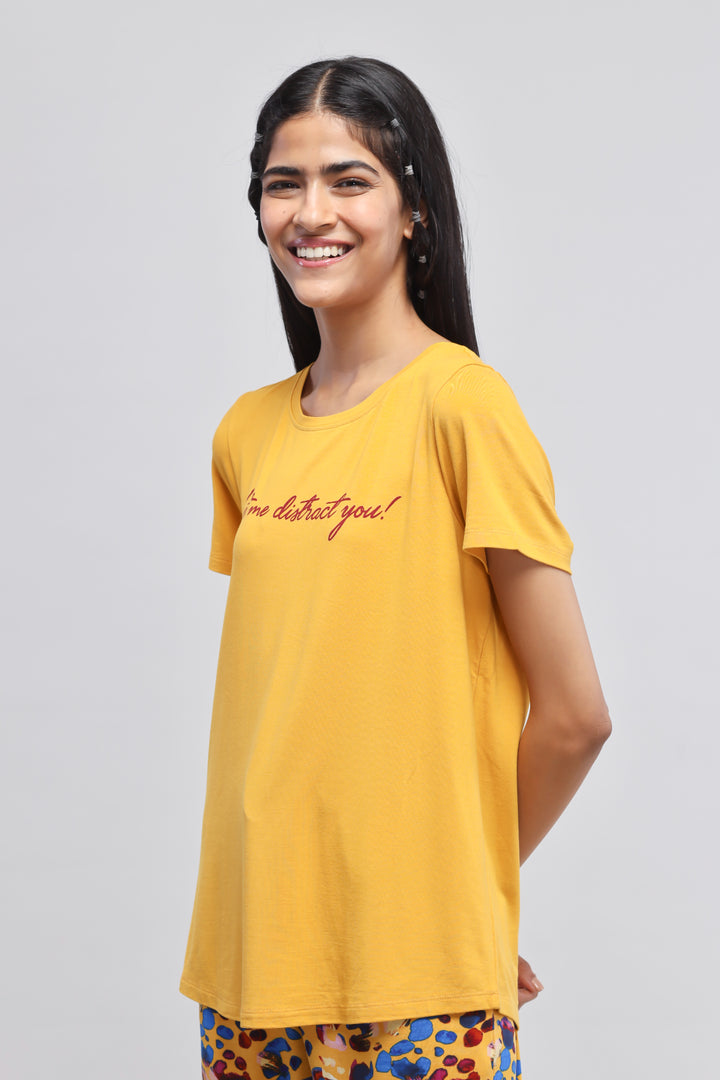 Cheerful model wearing leopard print pajama set and yellow t-shirt.