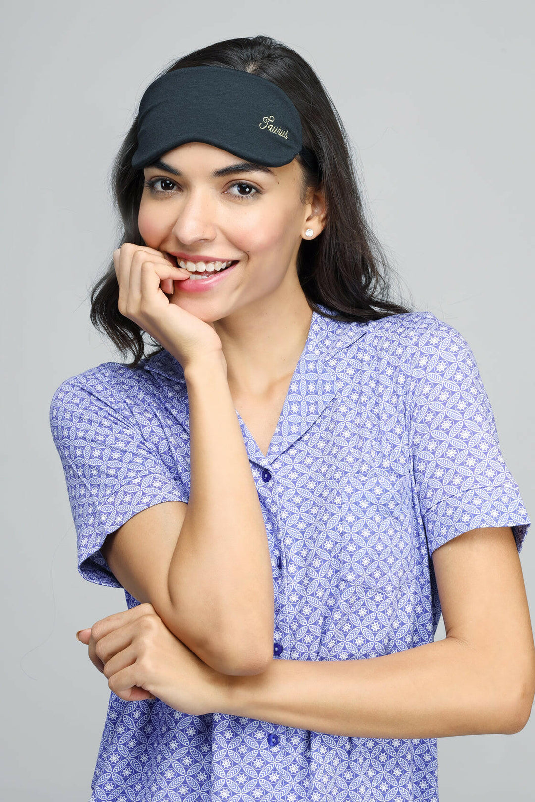 Smiling woman wearing Taurus Eye Mask, relaxing with stylish comfort.