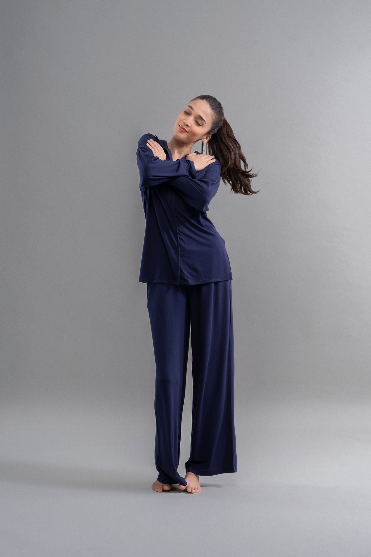Model wearing Deep Navy Supima Flared Pajamas in relaxing pose.
