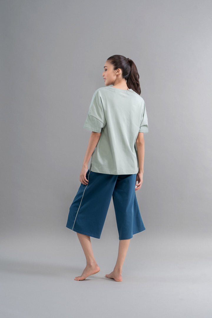 Sage teal cotton culotte set worn by model from behind.