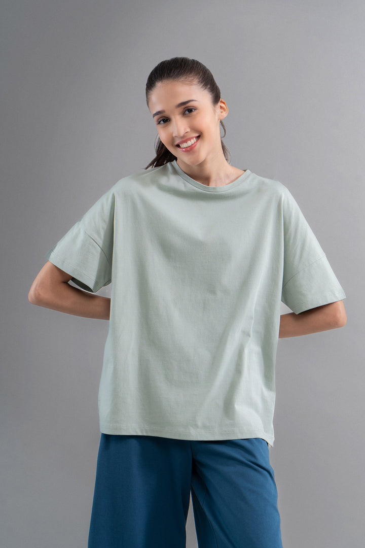 Sage cotton side slit T-shirt worn by smiling model.