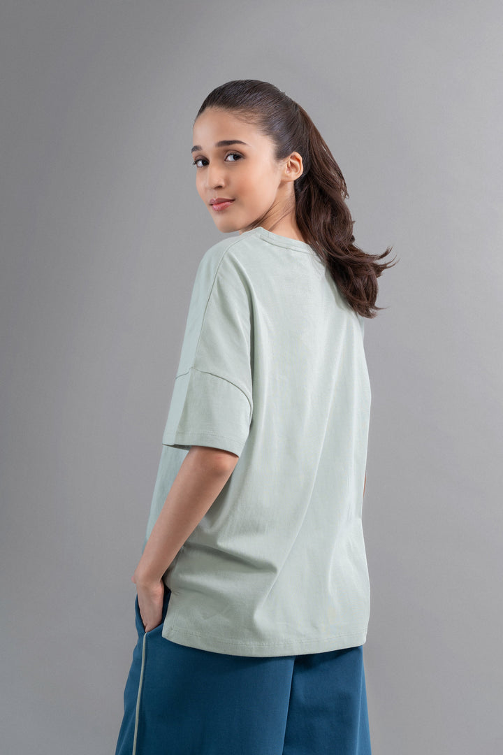 Sage cotton side slit t-shirt on model, casual chic style.