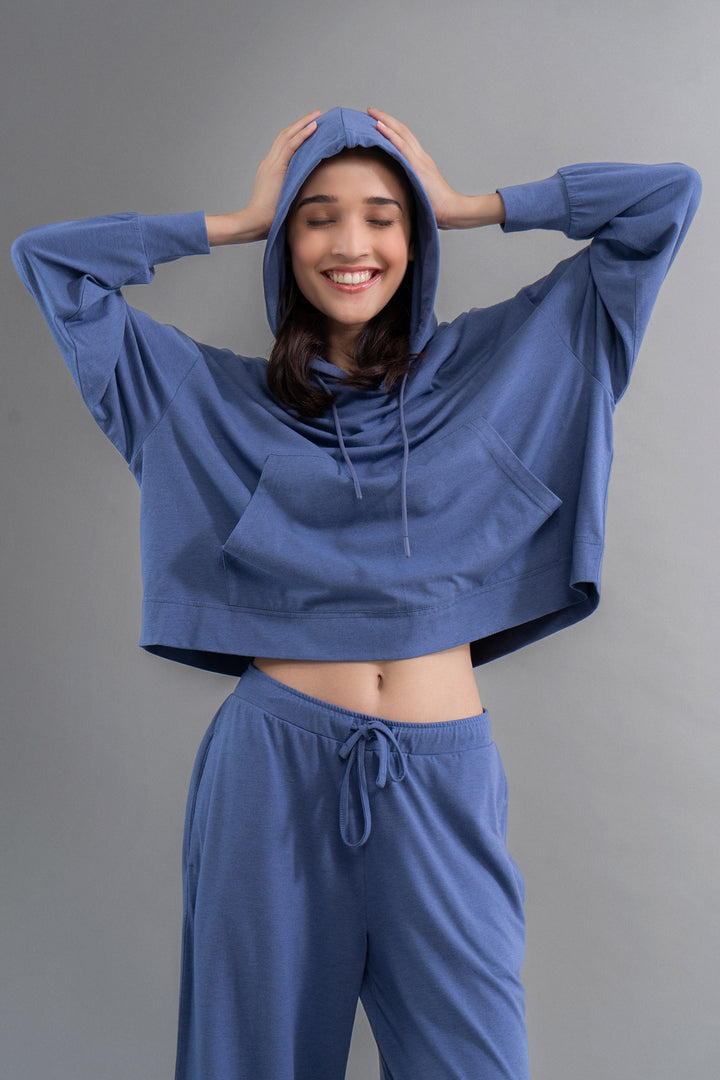 Smiling woman wearing a limited edition blue travel hoodie.