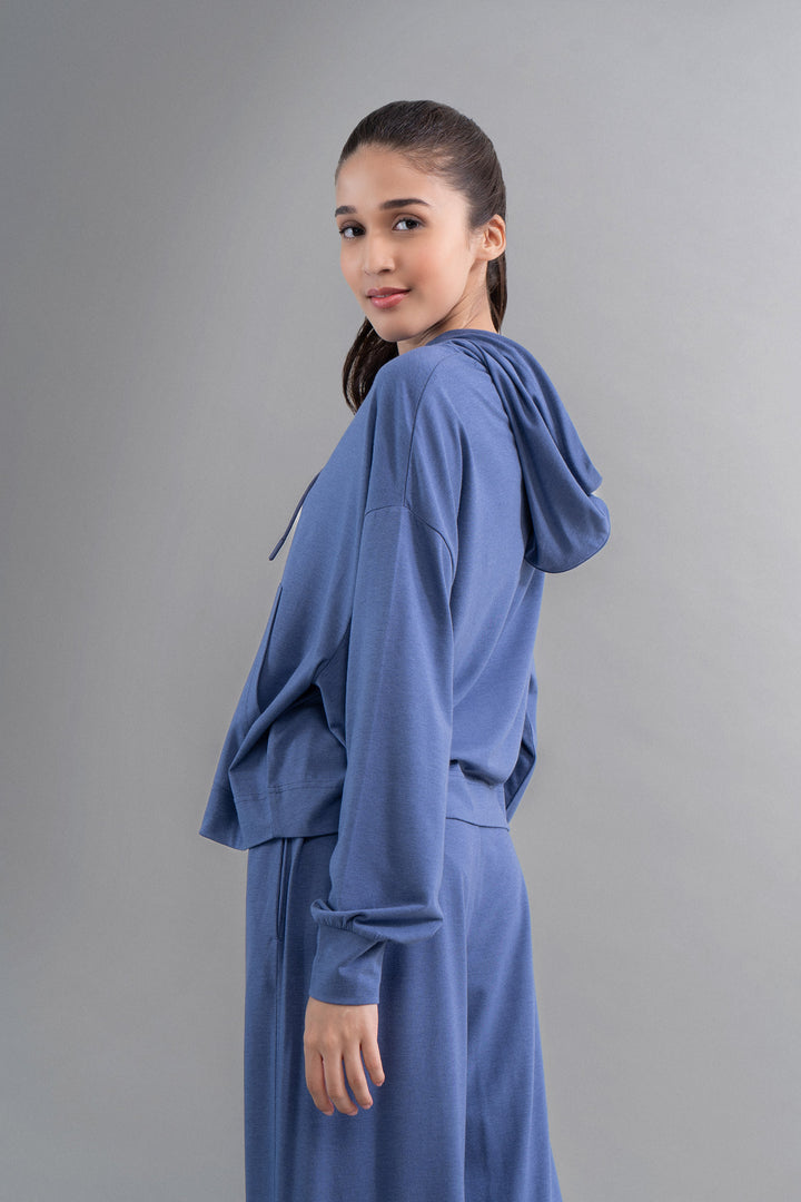 Limited Edition Luxflo® Travel Blue Hoodie on model against gray background.