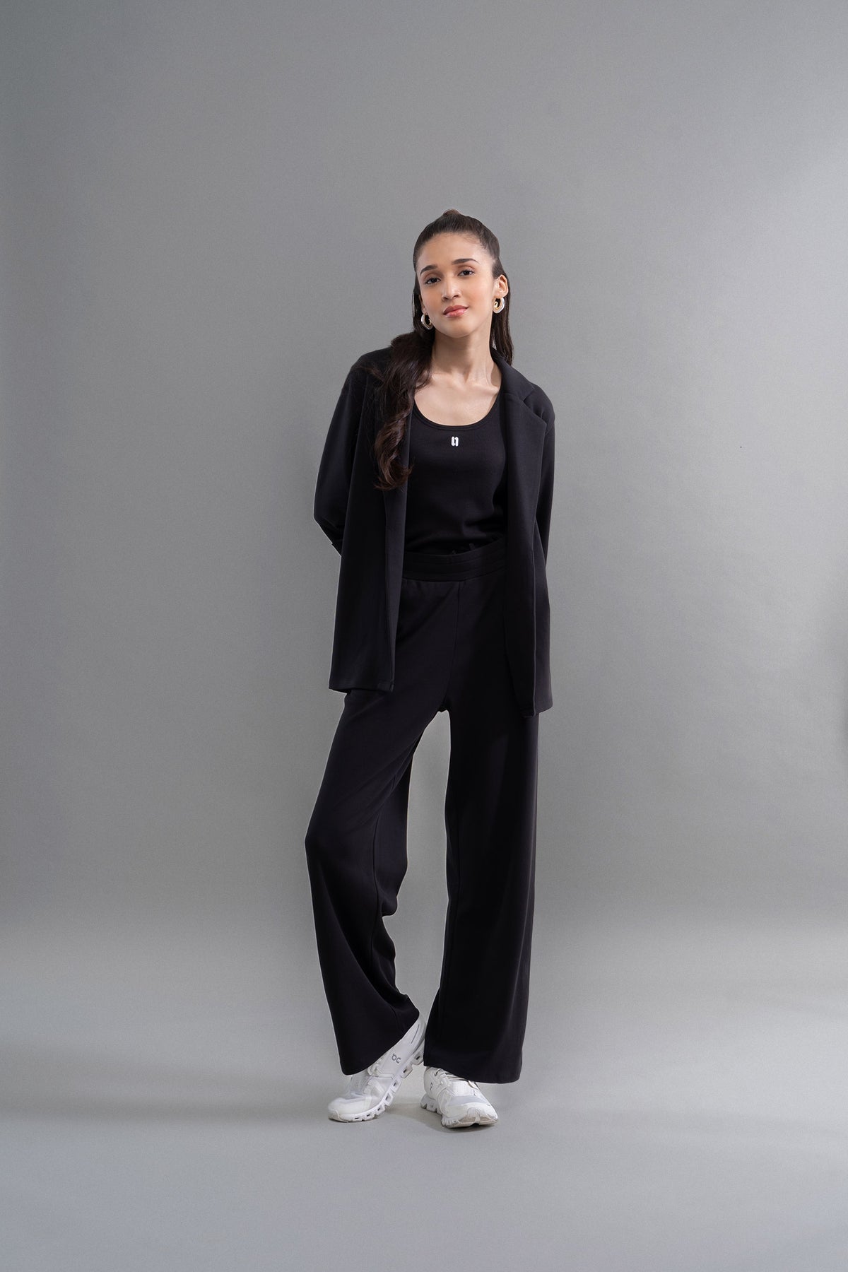 Model showcasing Snugknit® black flared pant with blazer and sneakers.