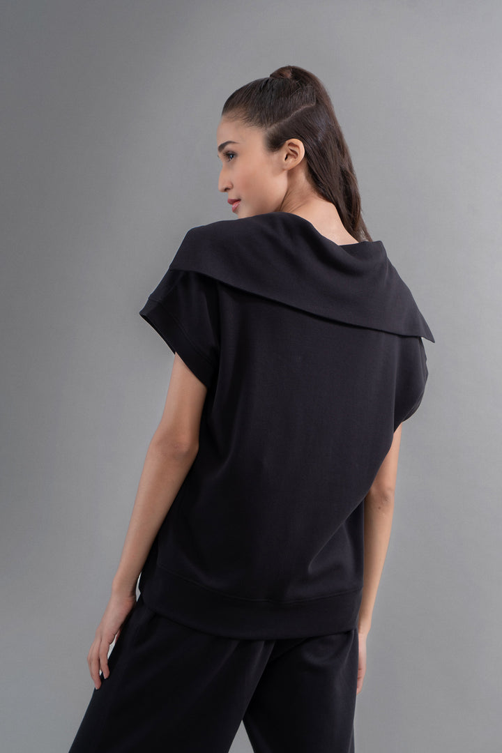 Woman wearing Snugknit® Black Polo Top from the back.