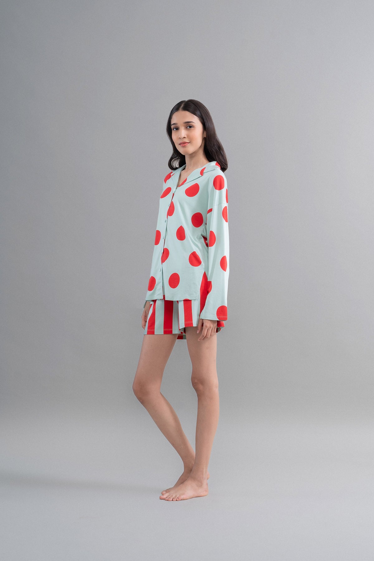 Sage button down shirt featuring red polka dots on a model.
