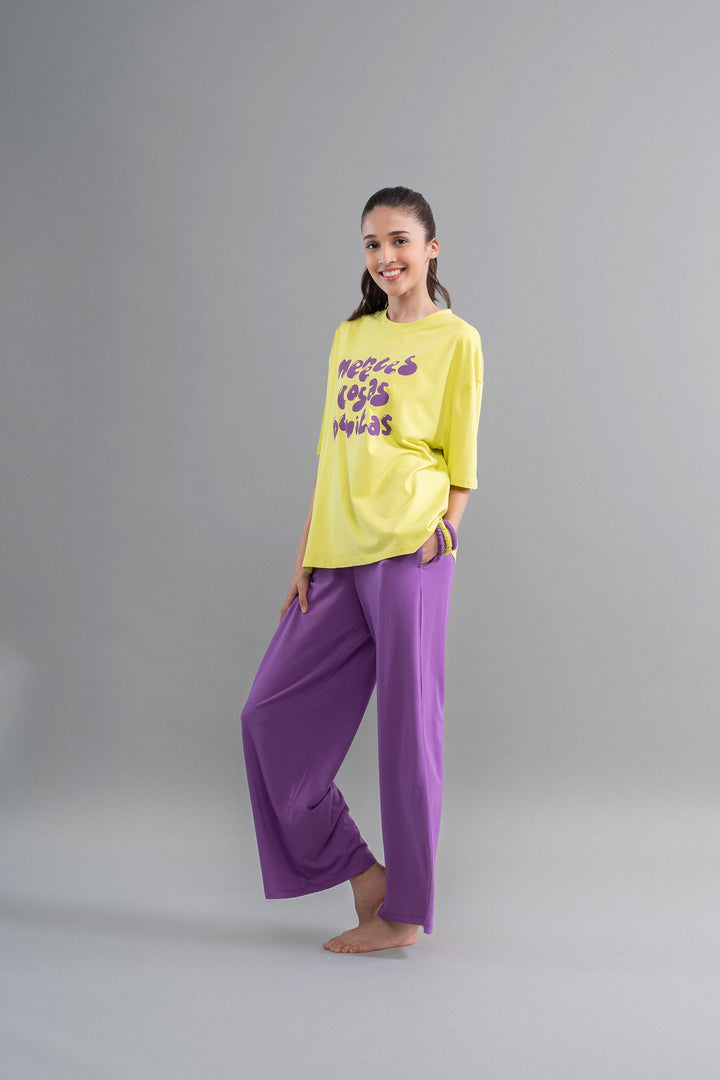 Model wearing Meadow Violet Supima Flared Pajamas set, yellow and purple combo.