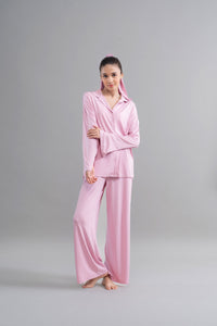 Deep pink modal button down pajama set modeled by a young woman.