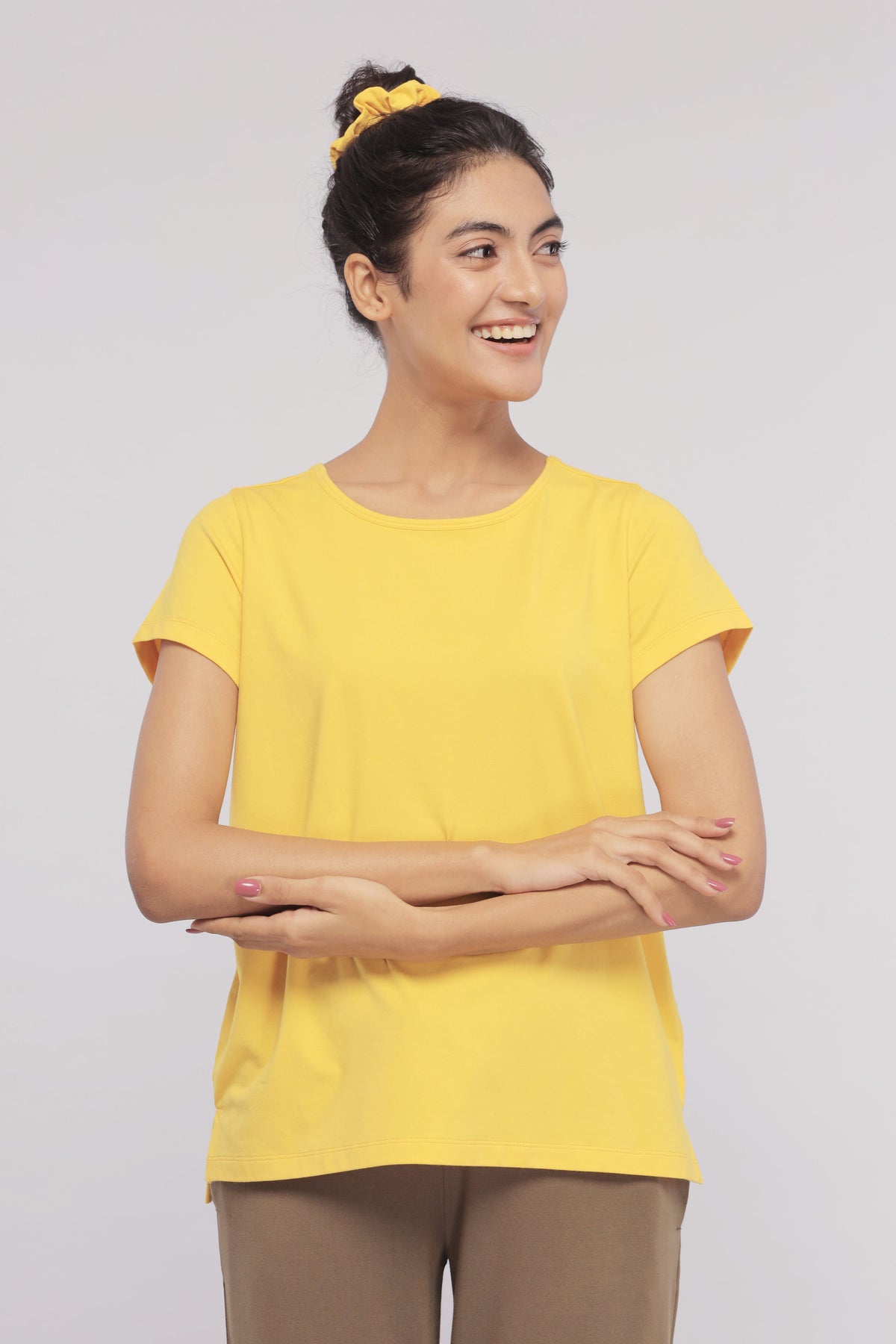 Sunny Lime Supima® round neck top on model, smiling in yellow.