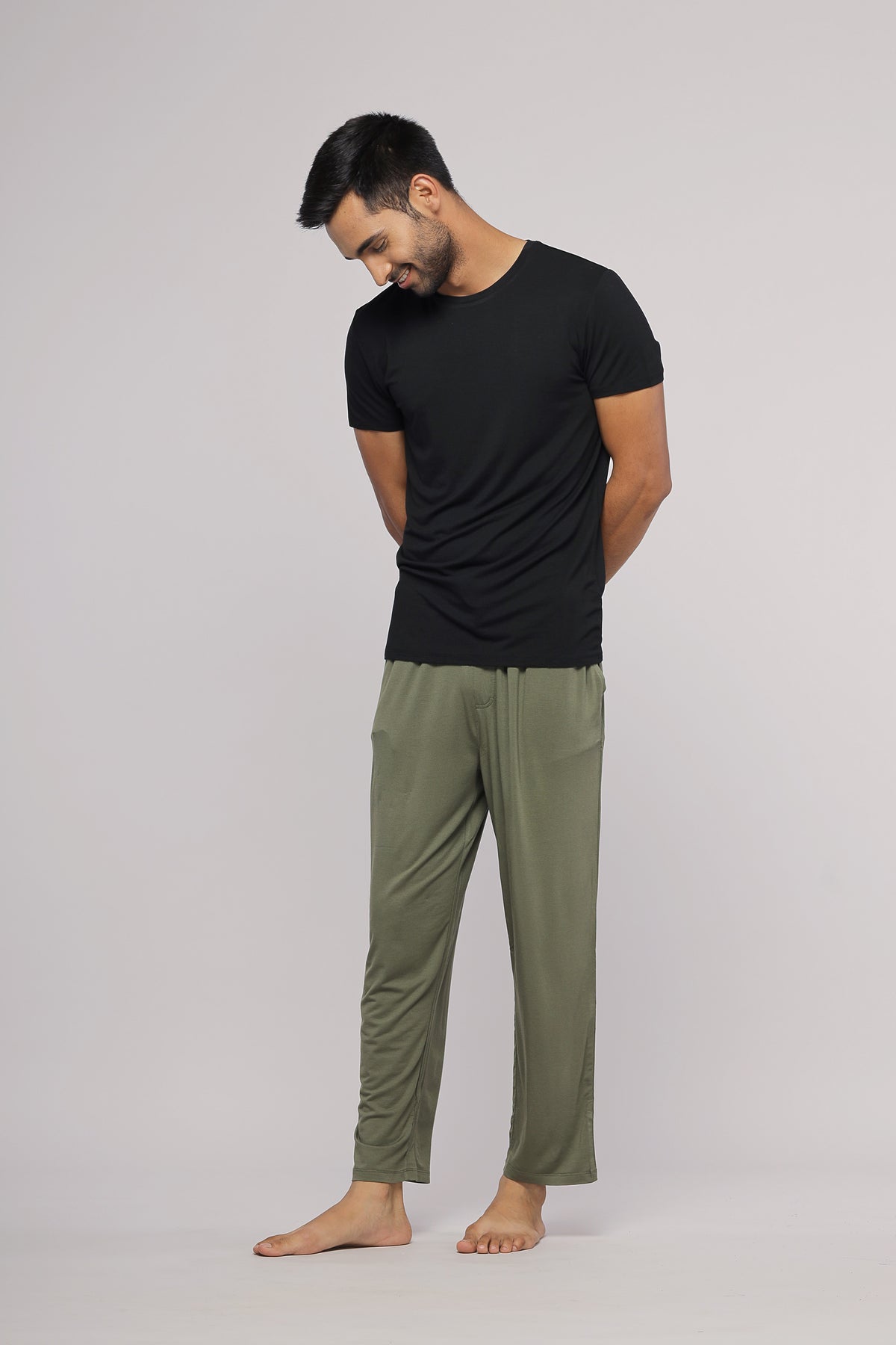 Black men's tee shirt styled with relaxed green pants.