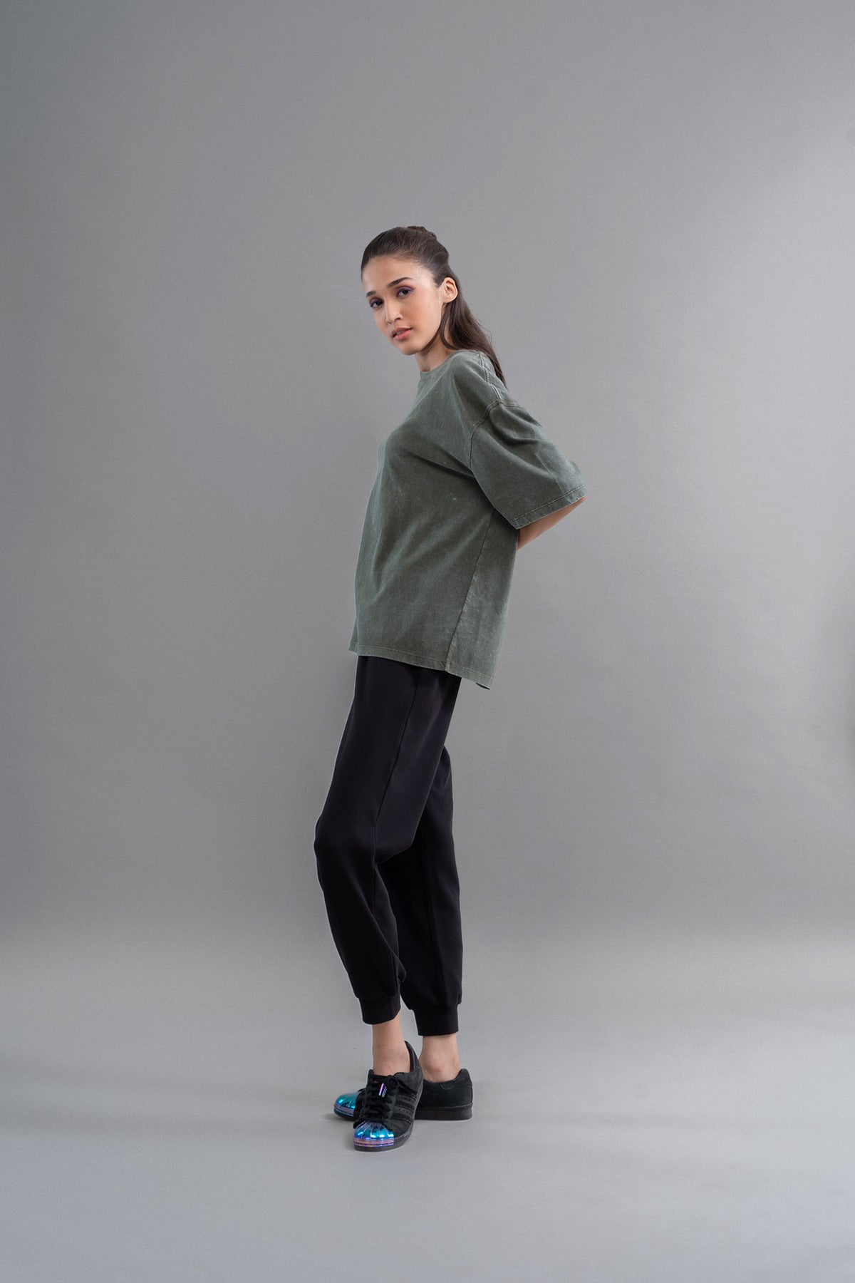 Green acid wash unisex t-shirt worn with black pants and sneakers.