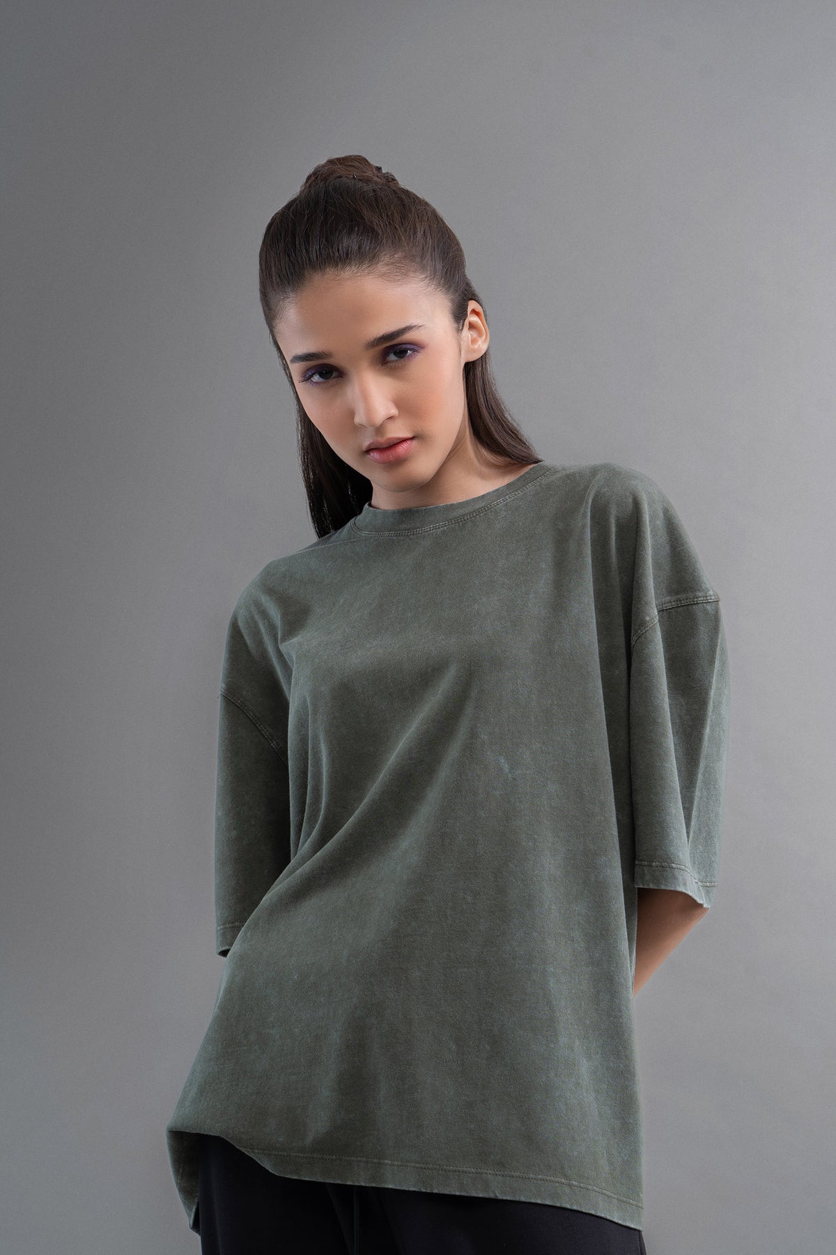 Green acid wash unisex t-shirt showcased by model against neutral background.