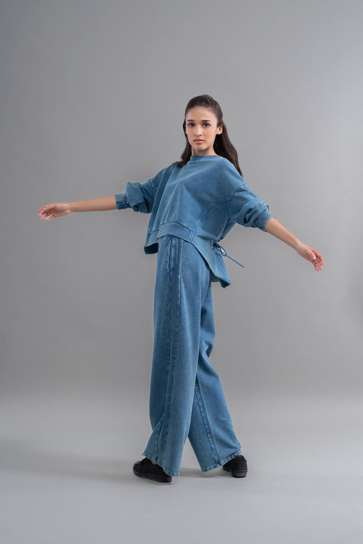Model showcasing denim wash 100% cotton terry ruched sweatshirt.