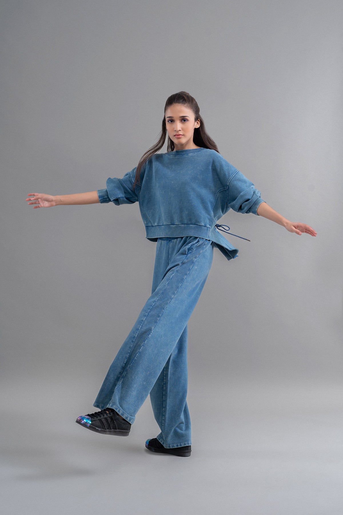 Model wearing denim wash 100% cotton terry ruched sweatshirt and pants.