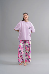 Enchanted Purple Cotton Pajama Set on model, featuring vibrant floral patterns.