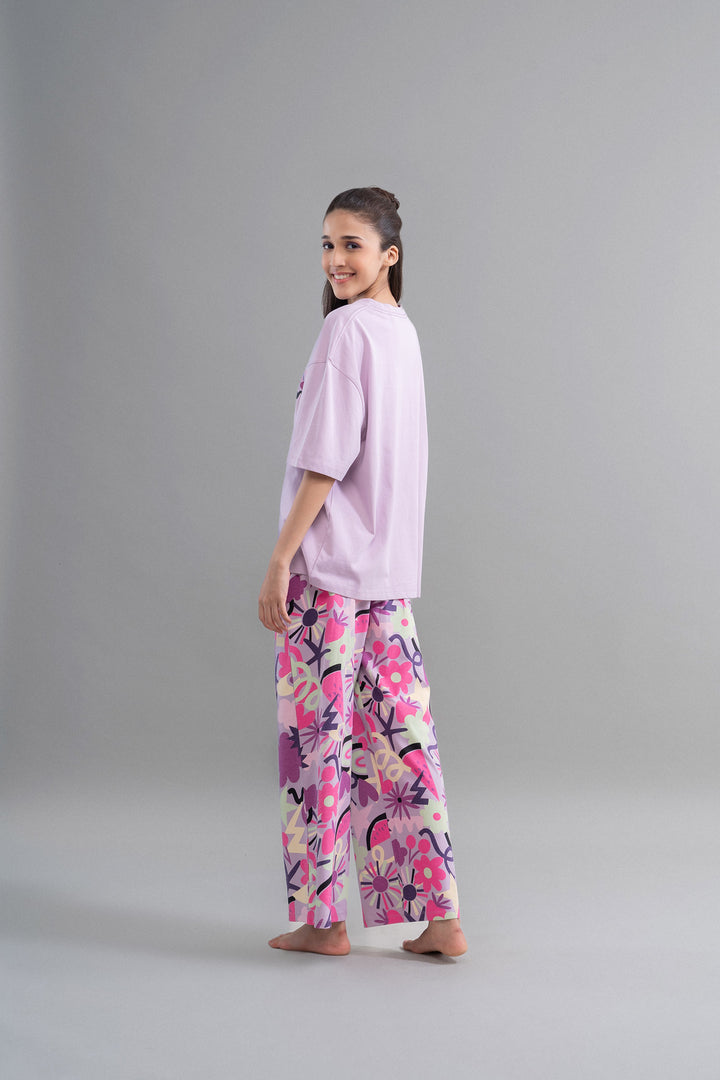 Model wearing Enchanted Purple Cotton Pajama Set with floral pattern.