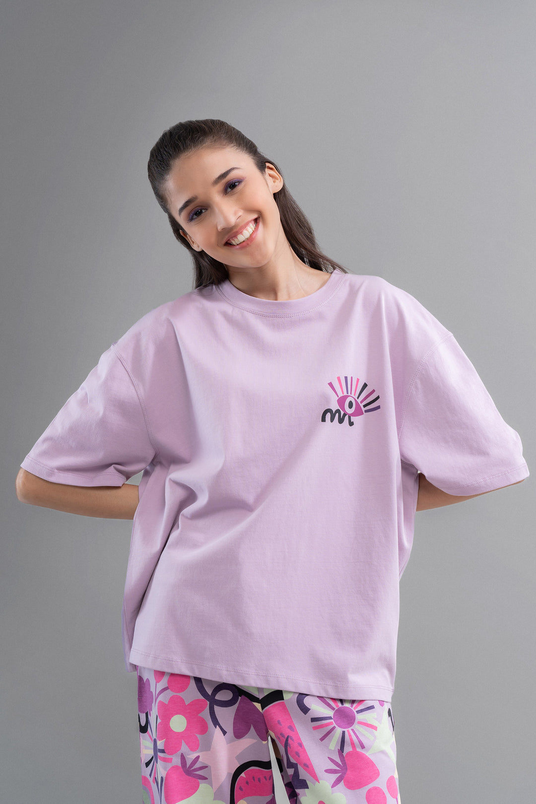 Model wearing Enchanted Purple Cotton Pajama Set featuring colorful floral patterns.