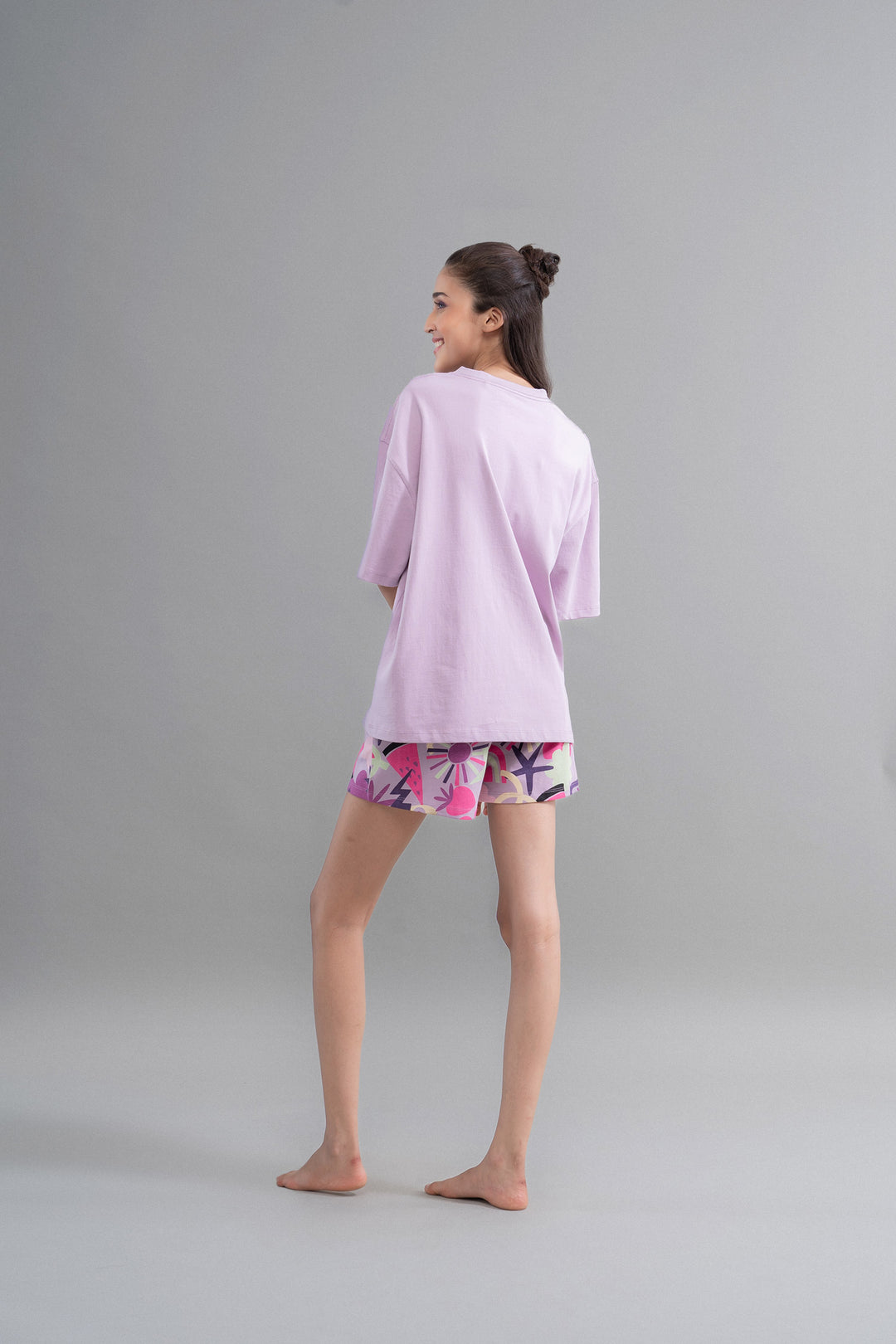 Model wearing Enchanted Purple Cotton Shorts with vibrant patterns.