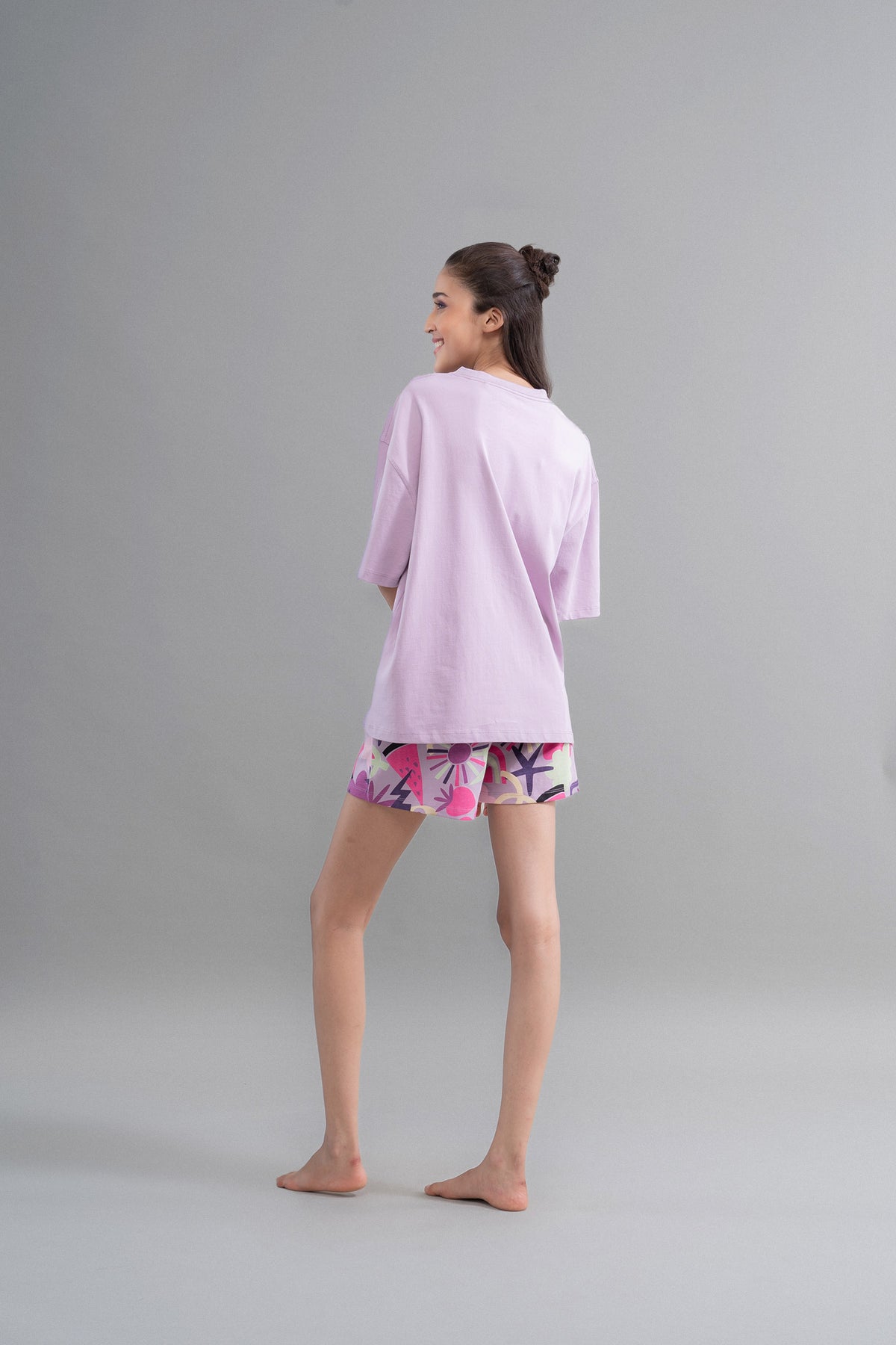 Model wearing Enchanted Purple Cotton Shorts with vibrant patterns.