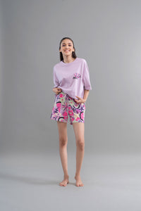 Woman wearing Enchanted Purple Cotton Shorts with vibrant floral design.
