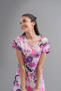 "Happy woman wearing Enchanted Purple Cotton Short Dress with vibrant patterns."
