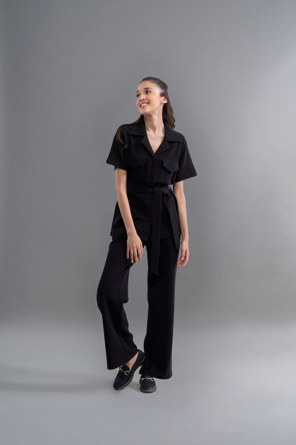 Model wearing Lushknit® 2.0 Black Straight Multitask Pants against gray background.