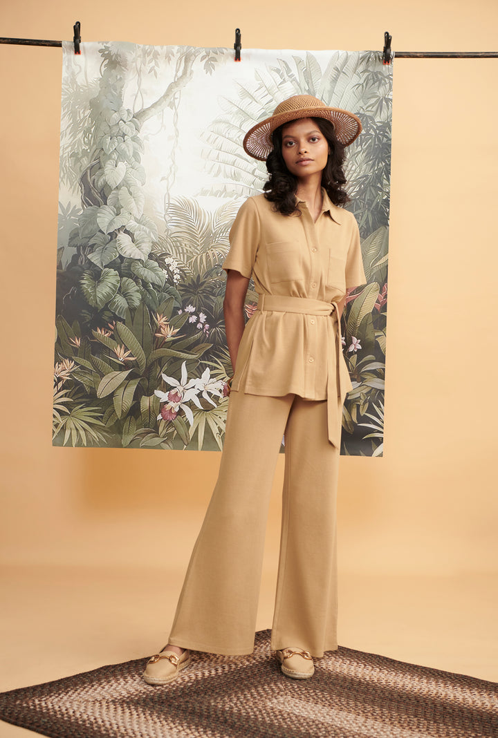 Model wearing Mini Waffle Brown Safari outfit against tropical backdrop.