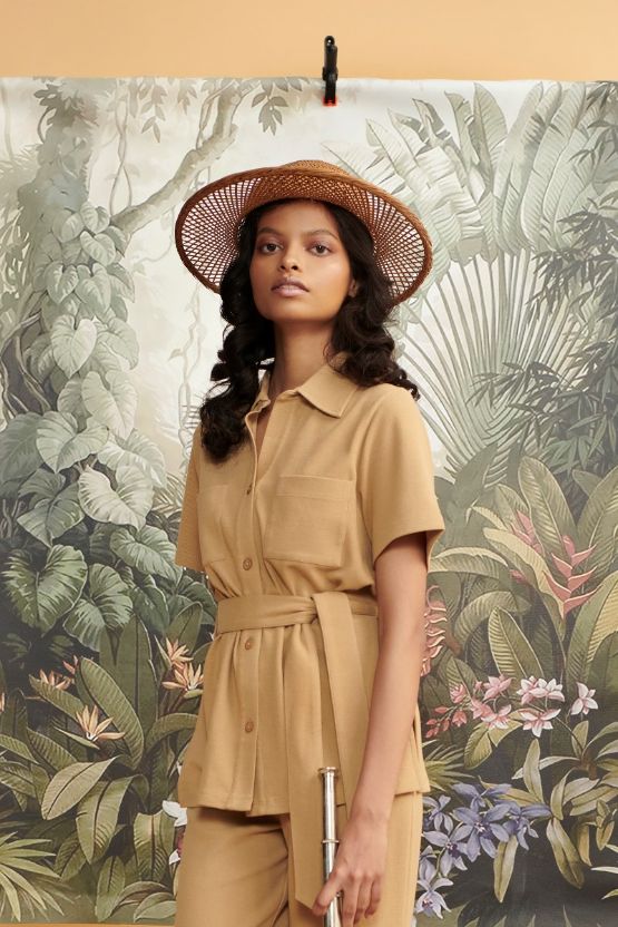Model wearing Mini Waffle Brown Safari outfit with tropical backdrop.