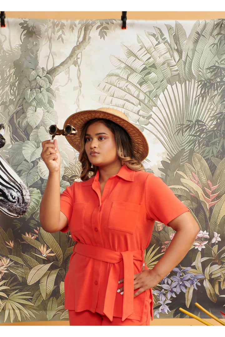 Model wearing Mini Waffle Red Safari Bermuda Set with tropical backdrop.