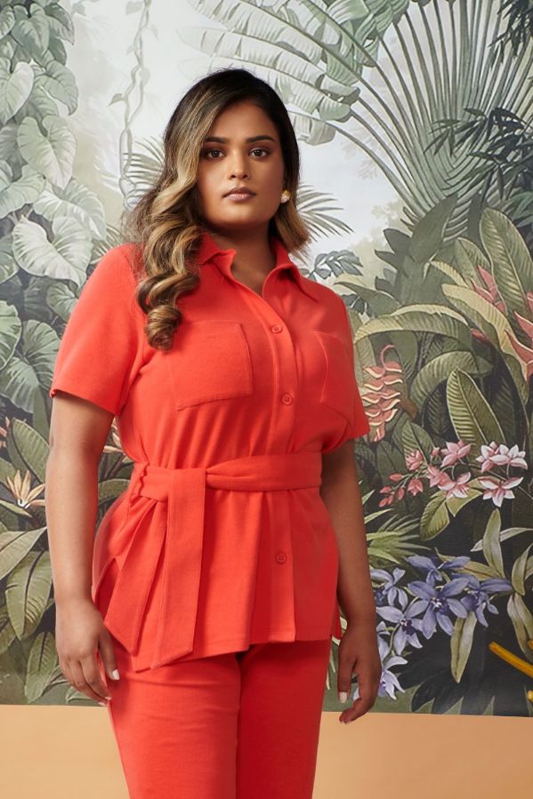 Model wearing Mini Waffle Red Safari outfit against tropical background.