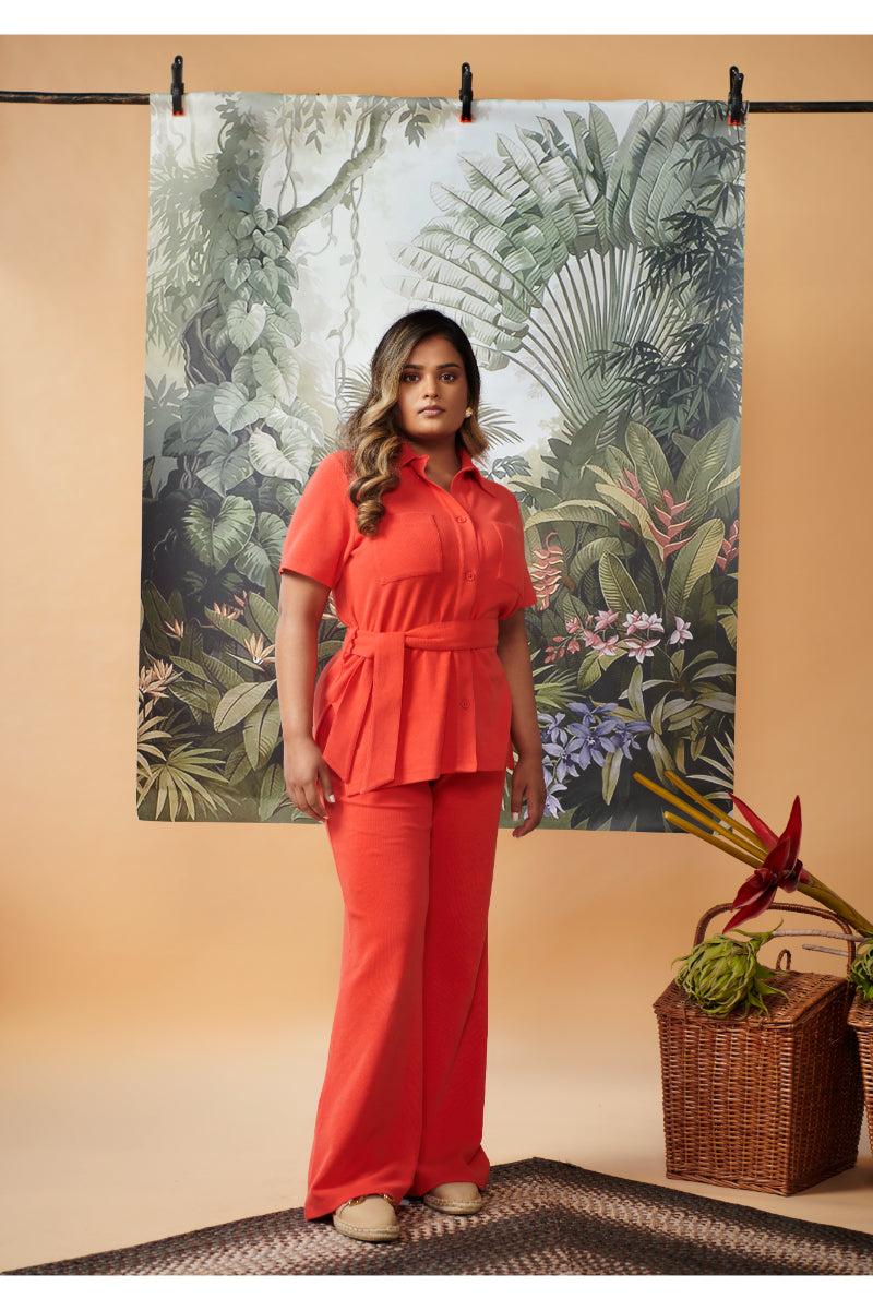 Mini waffle red flared pants outfit in stylish tropical setting.