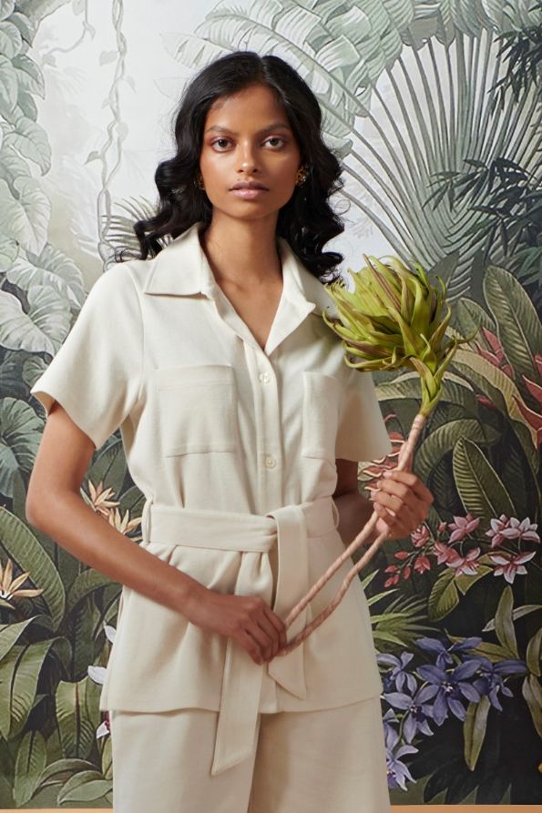 Model wearing Mini Waffle Ivory Safari outfit with tropical backdrop.