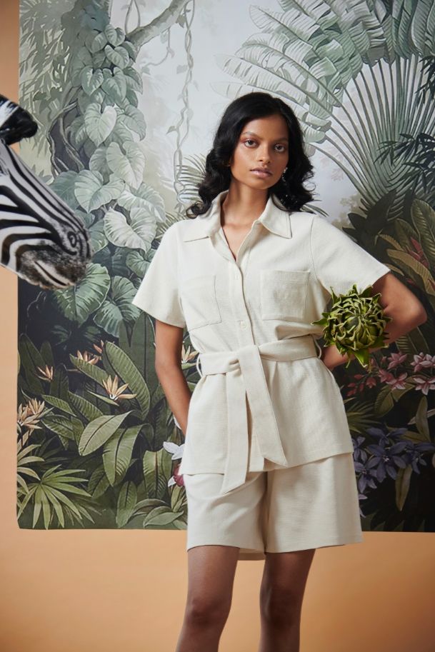 Model showcasing Mini Waffle Ivory Safari outfit in tropical setting.