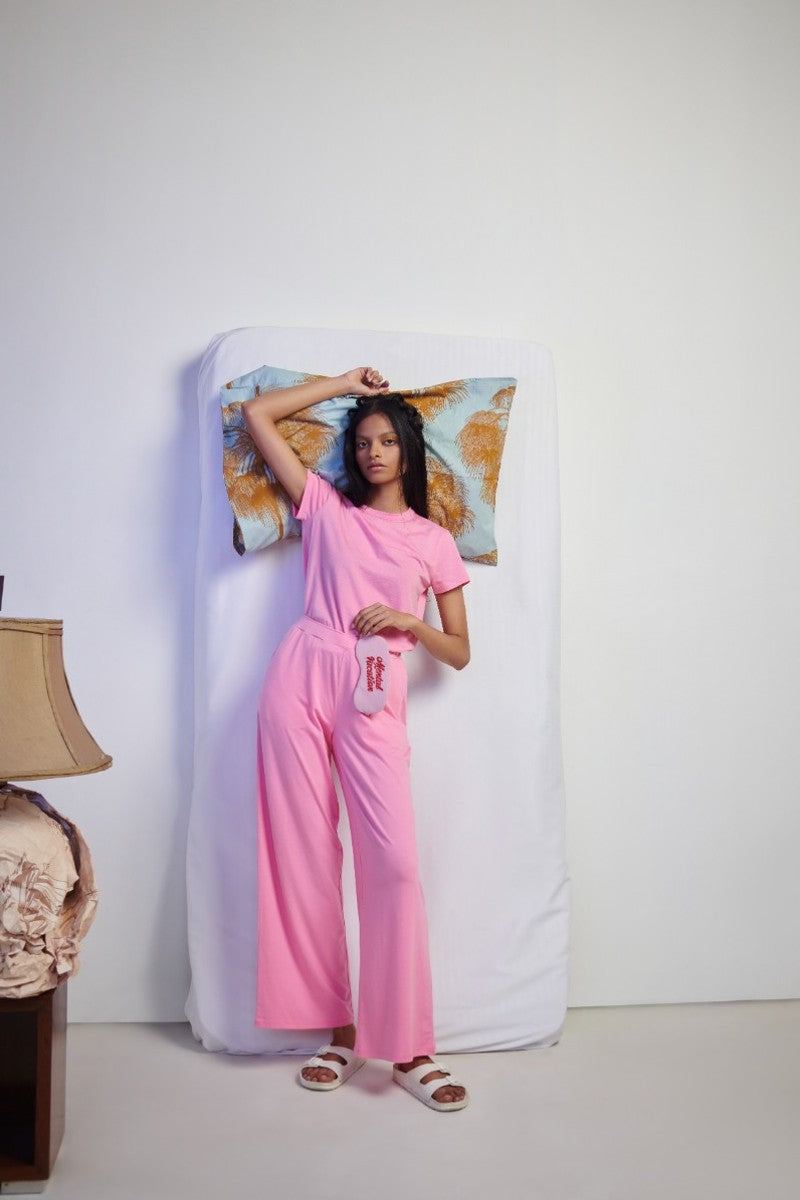 Model showcasing Pink Supima® Flared Pants in a modern setting.