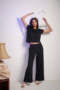 Model showcasing black Supima® co-ord set with pillow.