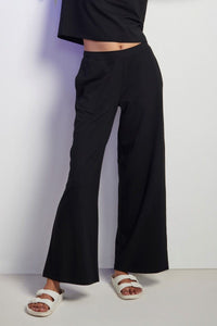 Black Supima® flared pants styled with a casual top and sandals.