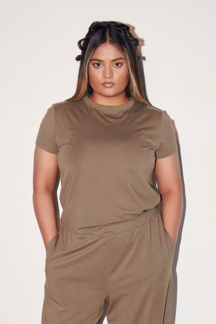 Olive Supima® T-Shirt displayed on a model in minimalist setting.