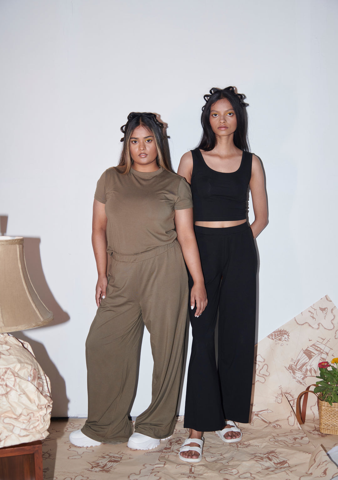 Two models in stylish olive and black flared pants.