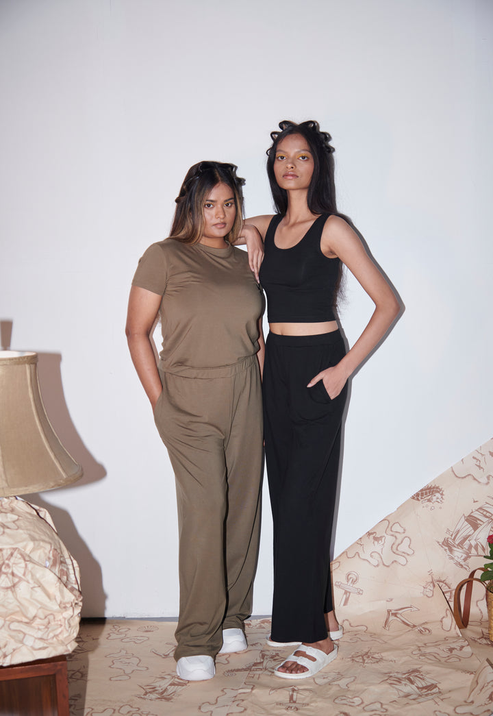 Olive Supima® flared pants styled with casual tops in modern setting.