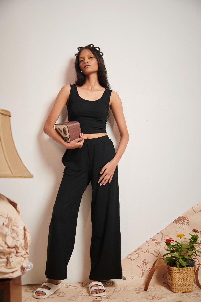 Black Supima® flared pants styled with a crop top in a chic setting.