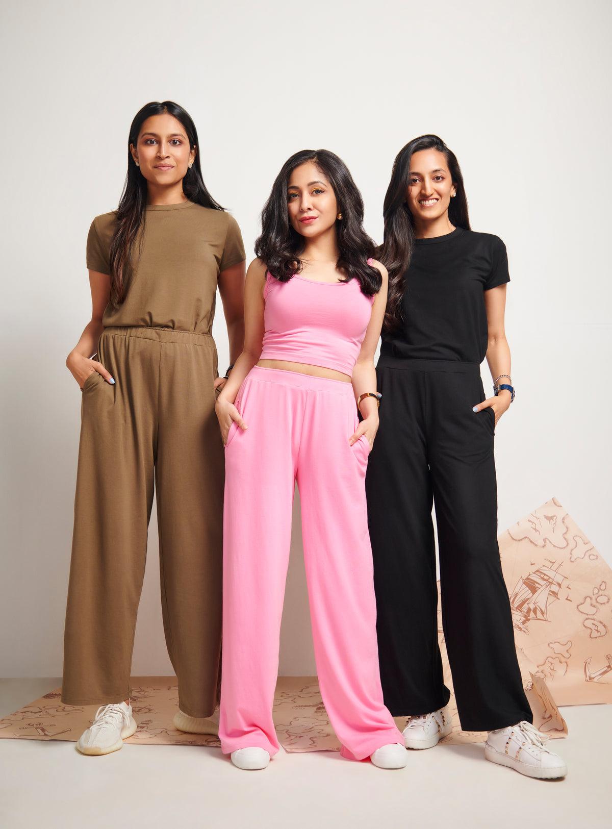 Three models showcasing Pink Supima® Flared Pants in stylish outfits.