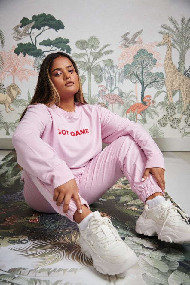 Bamboo Terry Pink Travel Joggers model seated in stylish athleisure wear.