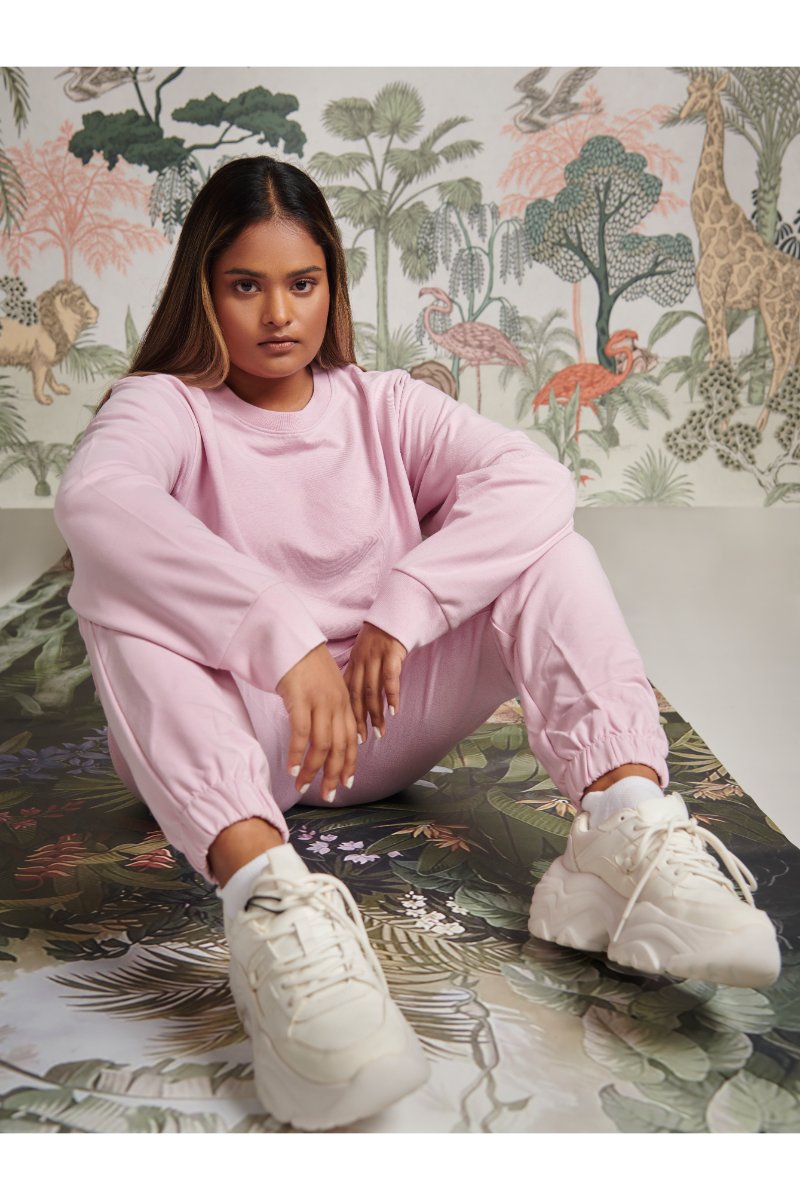 Model wearing a pink bamboo terry sweatshirt and matching pants.