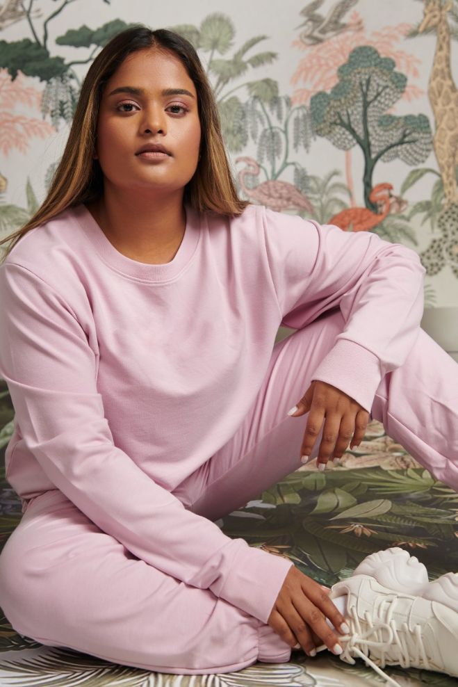 Bamboo Terry Pink Travel Joggers model sitting in stylish outdoor setting.